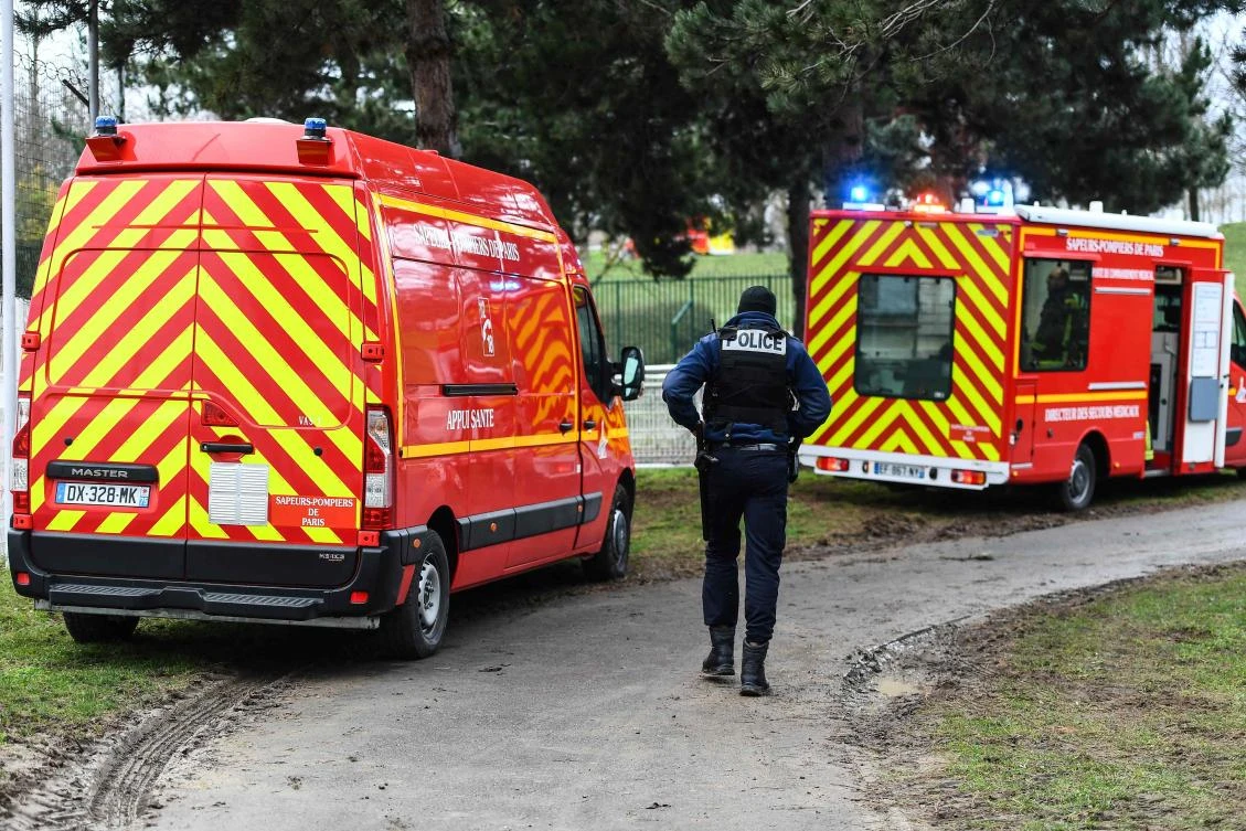 A policeman walks by firefighters vehicles in a park in the south of Paris' suburban city of Villejuif on January 3, 2020 where a man was shot and killed by officers after stabbing passers-by. (AFP)