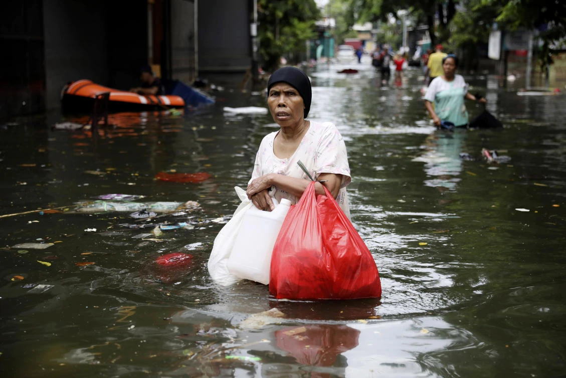 A woman wades flood water in Jakarta, Indonesia, Saturday, Jan. 4, 2020. (AP)