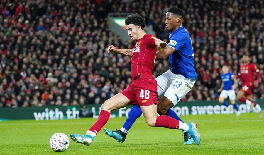 Liverpool’s Curtis Jones, left, challenges for the ball with Everton’s Yerry Mina. (AP)