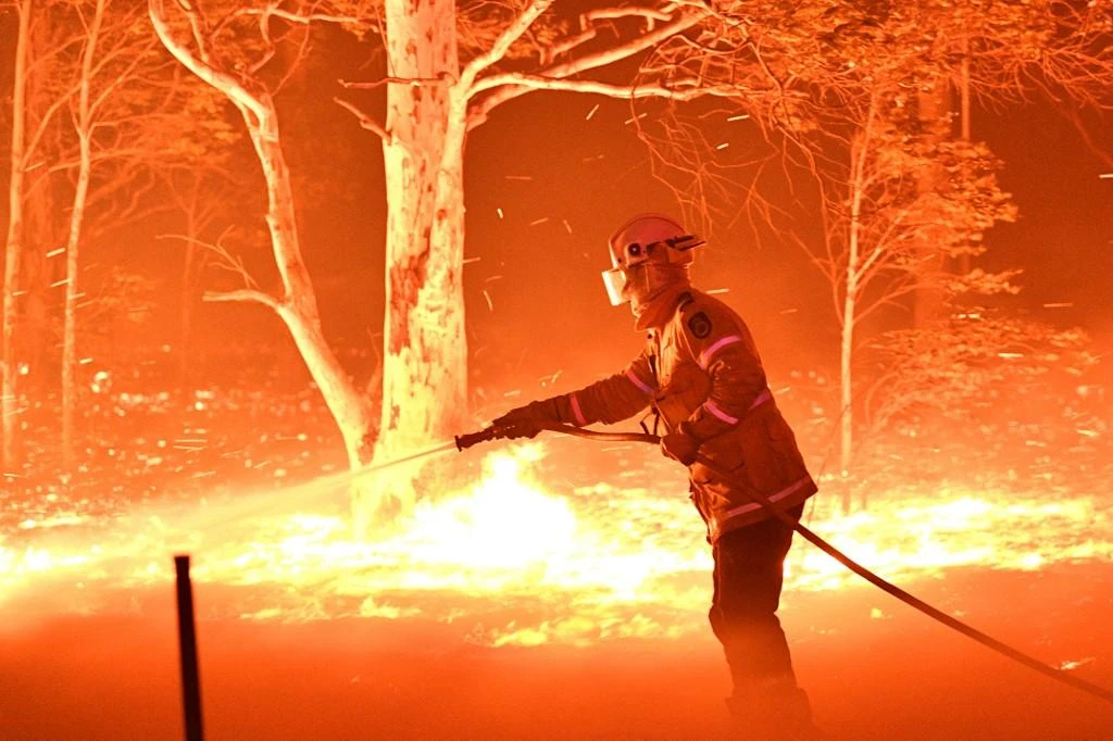 Exhausted firefighters in Australia raced to shore up defenses against deadly wildfires before the blazes flare again. (AFP)