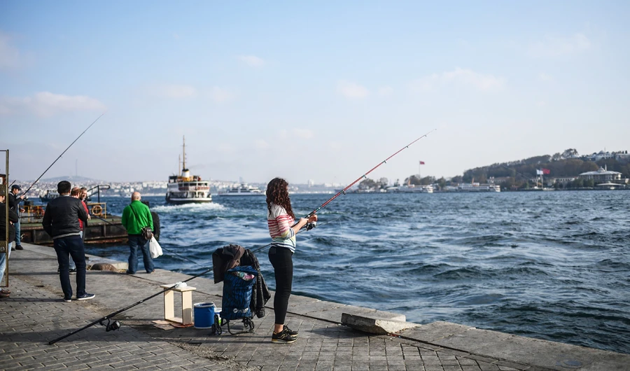 A woman is fishing next to the bosphorus river on November 15, 2017 at Karakoy district in Istanbul. (AFP)