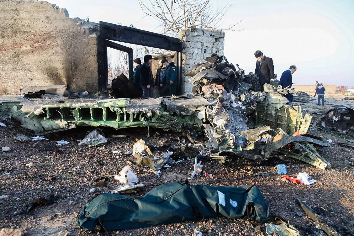 People stand near the wreckage after a Ukrainian plane carrying 176 passengers crashed near Imam Khomeini airport in Tehran on January 8, 2020. (AFP)