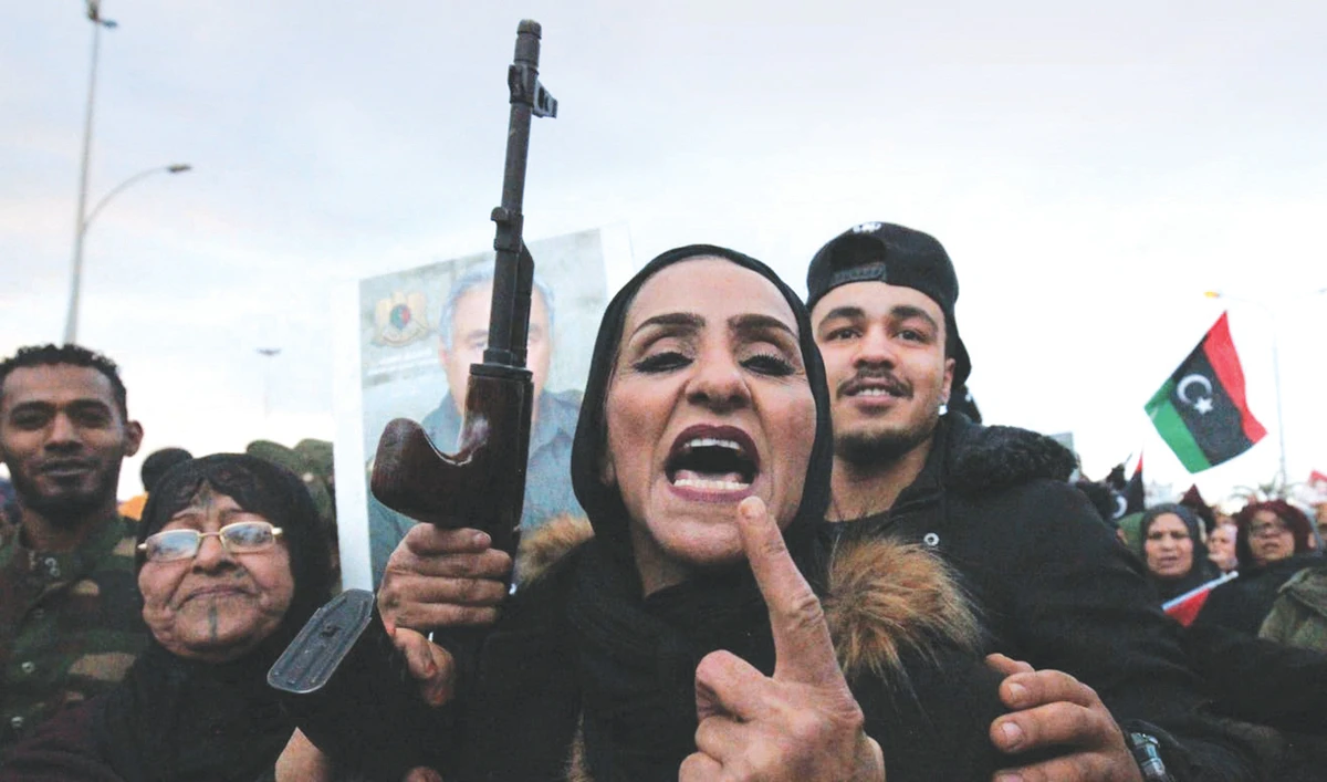 A woman brandishing a rifle takes part in a demonstration held by Libyans in Benghazi to protest against Turkey’s prospective military intervention. (AFP)