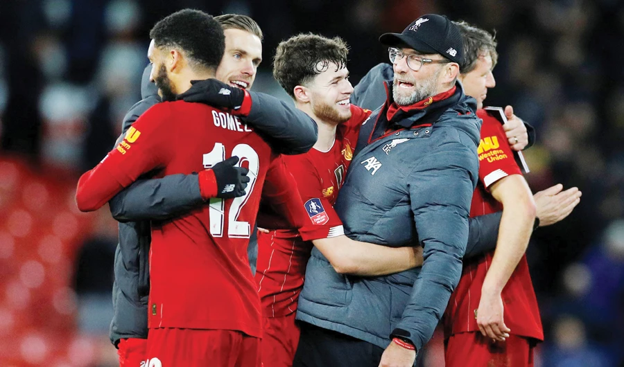 Liverpool players celebrate with manager Juergen Klopp after winning their match against everton. The reds will play against Tottenham on Saturday. (Reuters)