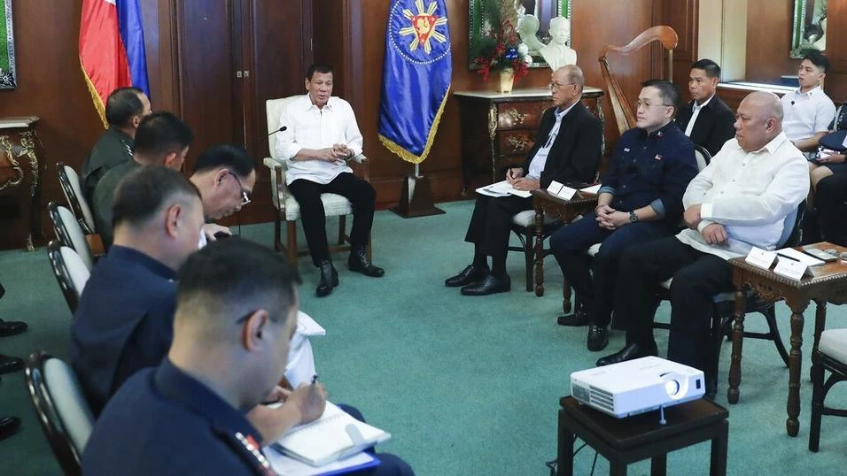 Philippine President Rodrigo Duterte, center, talks with security officials at the Malacanang presidential palace in Manila. (AP Photo)