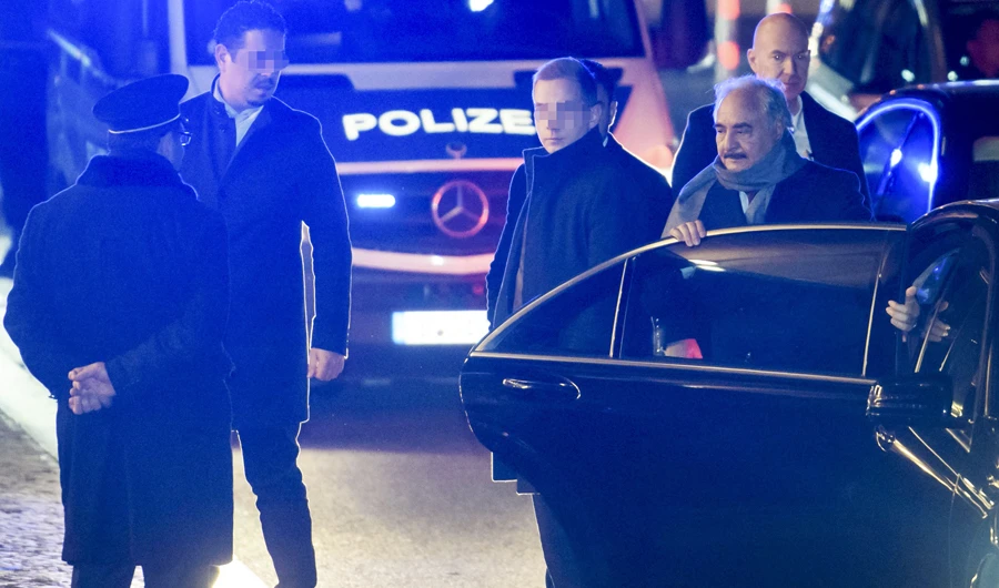 Libyan strongman Khalifa Haftar (2ndR) is surrounded by security personnel as he gets out of his car upon his arrival at his hotel in Berlin on January 18, 2020, on the eve of a peace conference on Libya to be held at the Chancellery. (AFP)