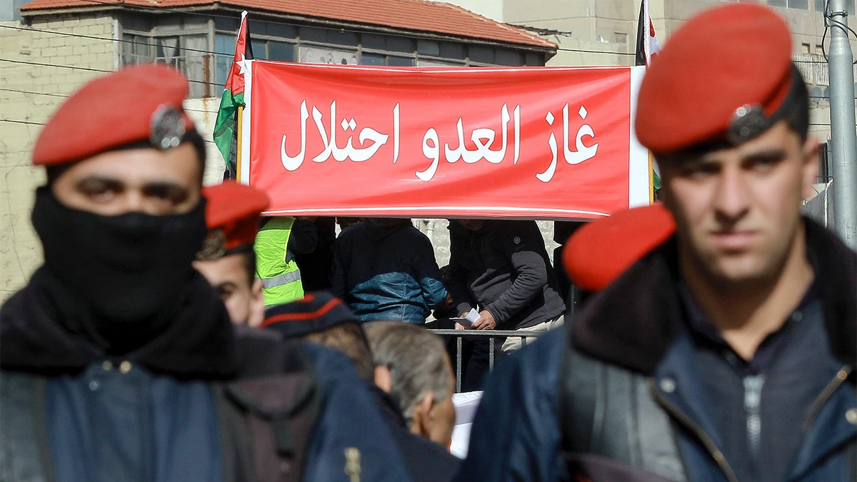 Jordanians wave a placard which reads in Arabic "The gas of the enemy is an occupation" during a demonstration in the capital Amman on Jan. 3, 2020, against the government's decision to import natural gas from Israel. (AFP/File)