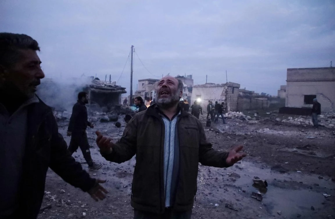 A Syrian man mourns the death of family members next to the rubble of his house following a reported airstrike on the village of Kafr Nuran, in the western countryside of the northern province of Aleppo, on January 21, 2020. (AFP)