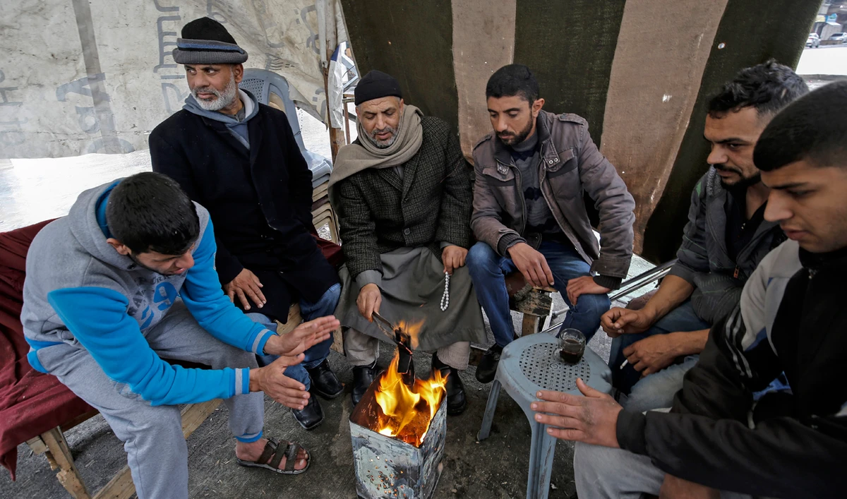 Palestinians warm themselves up in Gaza, which is called an open air prision because of Israeli restrictions. (AFP)