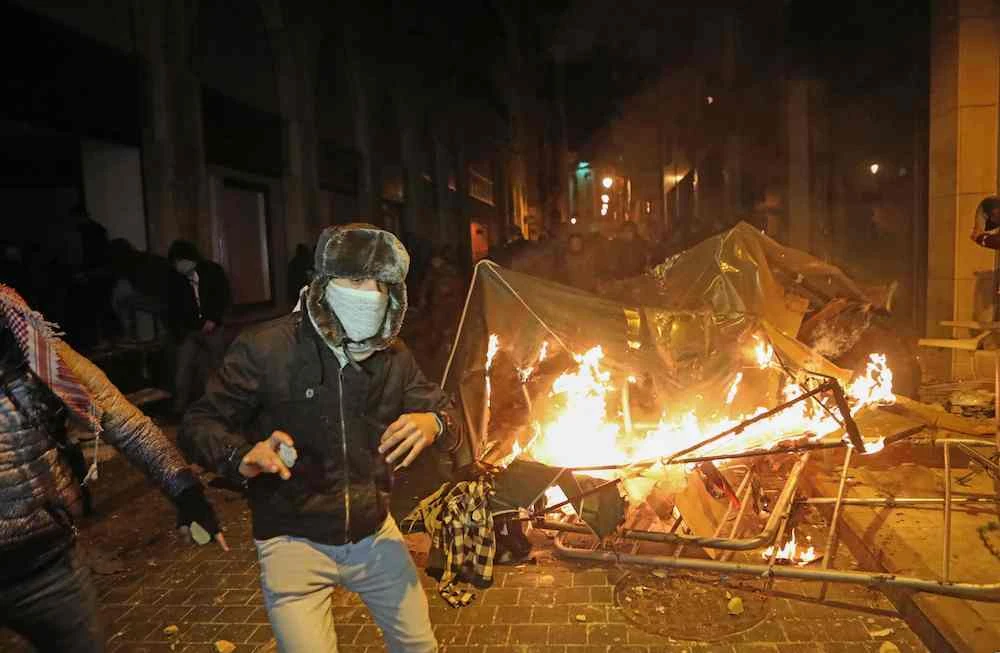 Lebanese anti-government protesters burn a police tent near the parliament during clashes with riot police. (AFP)