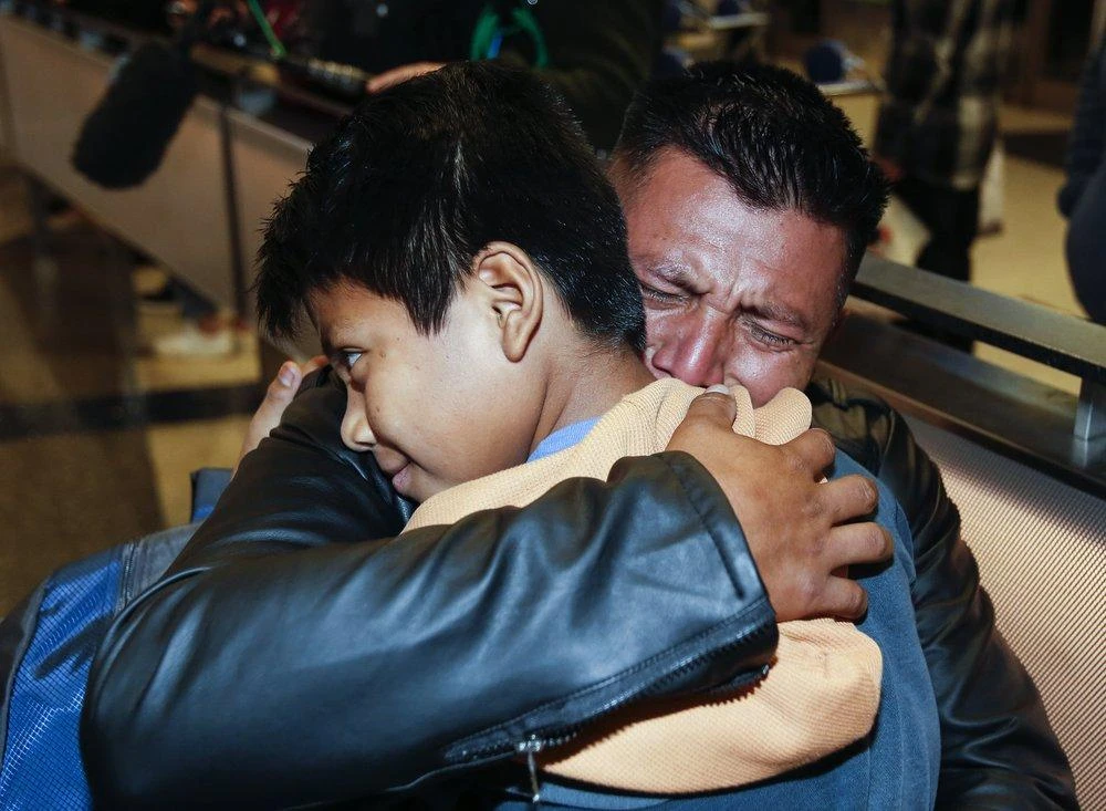 David Xol-Cholom, of Guatemala hugs his son Byron at Los Angeles International Airport as they reunite after being separated. (AP/Ringo H.W. Chiu)