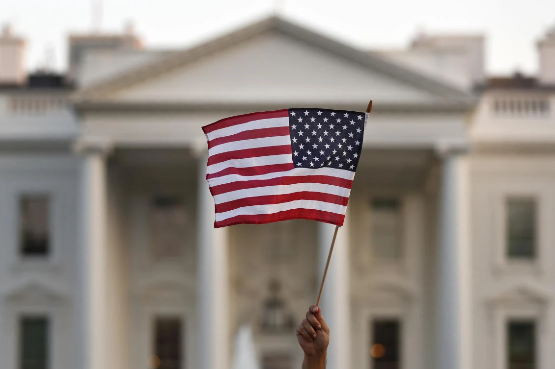 In this Sept. 2017 file photo, a flag is waved outside the White House, in Washington. The Trump administration is coming out with new visa restrictions aimed at restricting a practice known as “birth tourism." That refers to cases when women travel to the United States to give birth so their children can have U.S. citizenship. (AP)