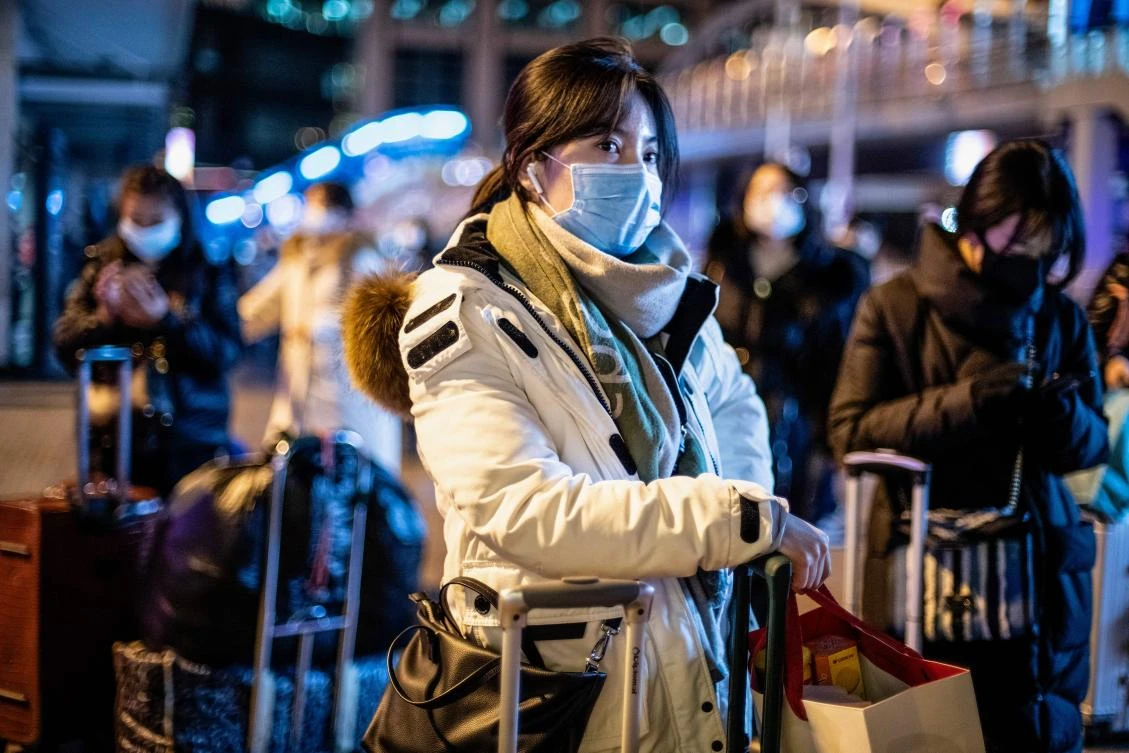 A woman wearing a protective mask looks on as she arrives at Beijing railway station ahead of the Lunar New Year in Beijing on January 23, 2020. (File/AFP)