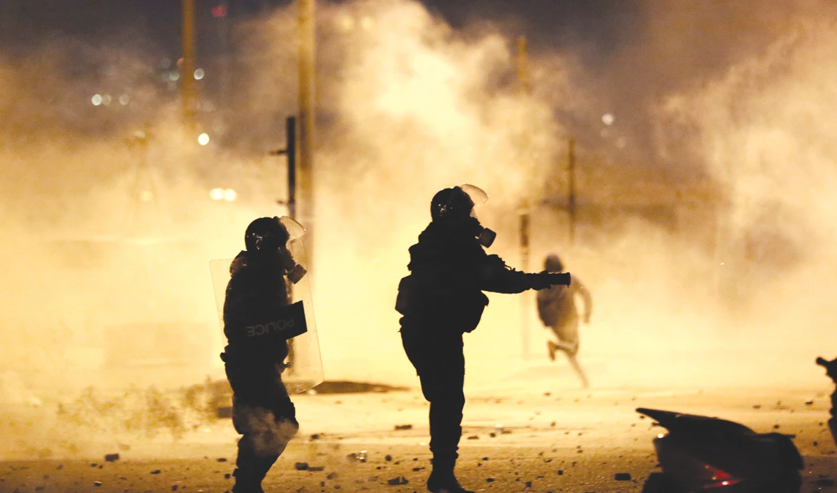 Riot police fire tear gas against the protesters, during a protest against the new government, in downtown Beirut, as the Hassan Diab government struggles to resolve the crises in the country. (AP)