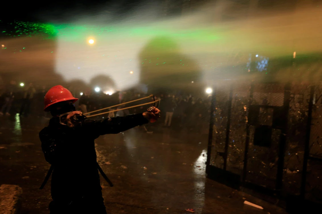 A demonstrator uses a slingshot to throw a stone during a protest against the newly formed government near the government headquarters in Beirut, Lebanon Jan. 25, 2020. (Reuters)