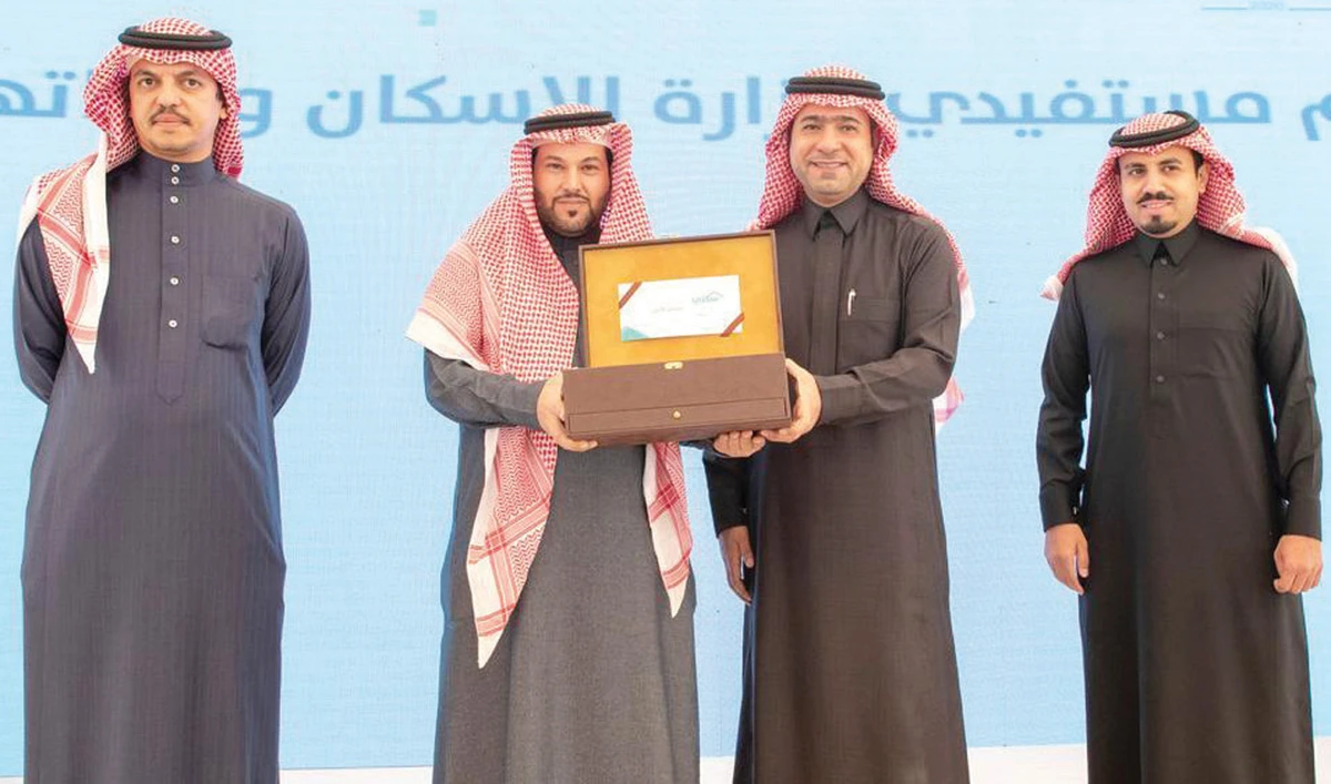 Housing Minister Majid Al-Hogail, second right, handed over housing units to beneficiaries of the Sakani program. (SPA)