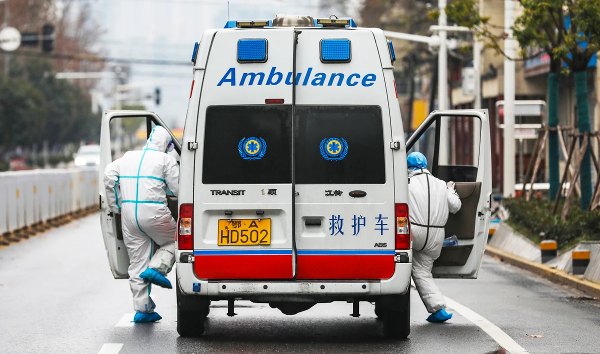 Ambulance crew members in protective gear get into their ambulance in Wuhan in central China's Hubei Province. (Chinatopix/AP)