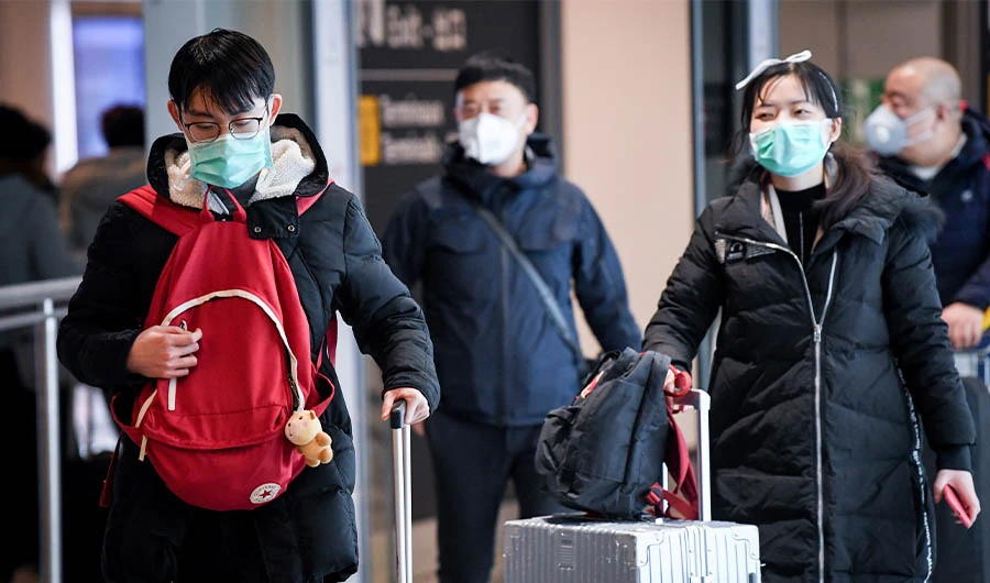 Passengers coming from China, leaves the Terminal wearing paper masks after landing in Charles De Gaulle Airport on January 26, 2020 in Roissy-en-France. (AFP)