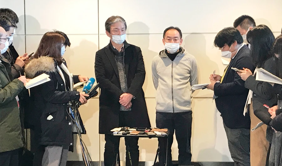 Wearing surgical masks, Takeo Aoyama, center left, and Takayuki Kato, center right, employees at Nippon Steel Corporation’s subsidiary in Wuhan, China, speak to journalists after returning home by a Japanese chartered plane at Haneda international airport in Tokyo Wednesday, Jan. 29, 2020. (AP)