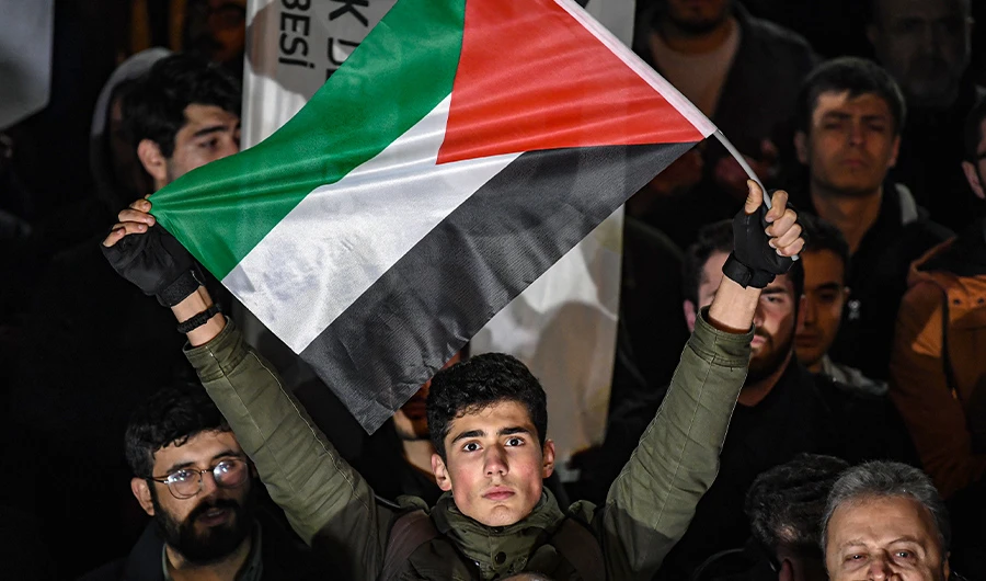 A man holds a flag of Palestine as protesters take part in a demonstration in front of the US consulate in Istanbul on January 29, 2020, to protest against the US peace plan. (AFP)