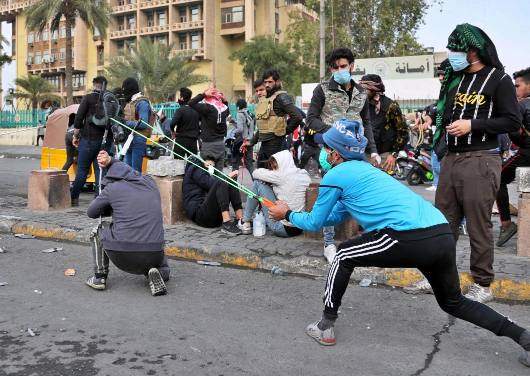 Anti-government protesters use a slingshot to fire a stone at security forces during clashes in Baghdad, Iraq, Wednesday, Jan. 29, 2020. (AP Photo/Hadi Mizban)