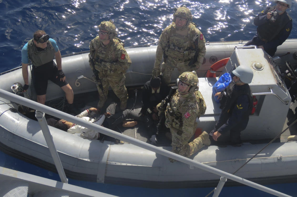 In this image provided by the Turkish Military, members of Turkish forces, left, carry migrants collapsed on the floor of the boat, rescued from aboard an inflatable dinghy in the mid Mediterranean Sea, Wednesday, Jan. 29, 2020. (AP)