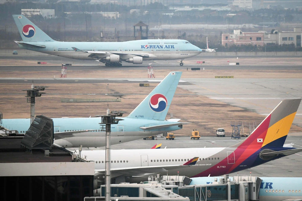 An airplane (top) carrying South Korean citizens repatriated from the Chinese city of Wuhan lands at Gimpo airport in Seoul on January 31, 2020. (AFP / Jung Yeon-je)