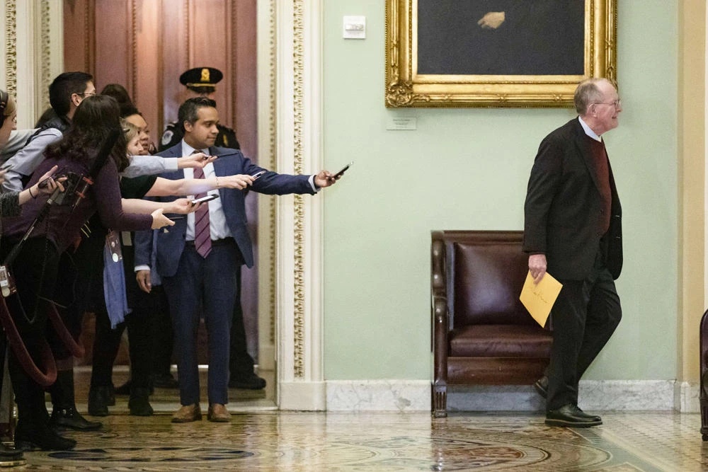 Reporters reach out with their cell phones and audio recorders trying to get a statement from Sen. Lamar Alexander as he passes by during a recess in the Senate impeachment trial of President Donald Trump on January 30, 2020 in Washington, DC. (Samuel Corum/Getty Images/AFP)