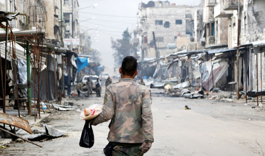 A Syrian army soldier carries food as he walks through Maarat al-Numan, Syria January 30, 2020. (REUTERS)