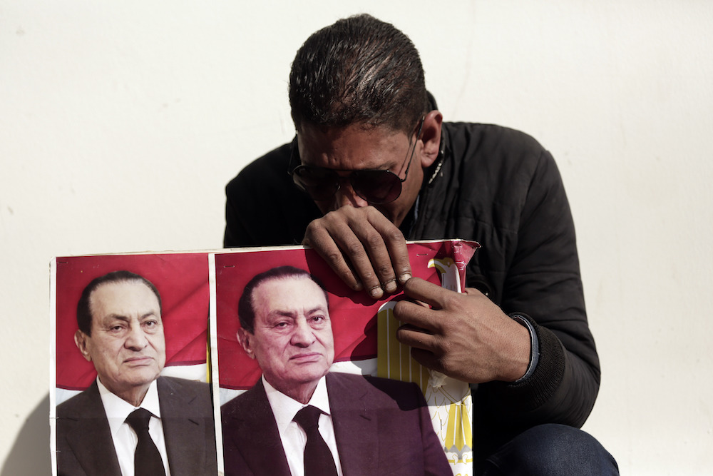 A supporter of ousted President Hosni Mubarak weeps outside of the El-Mosheer Tantawi Mosque before his funeral. (AP)