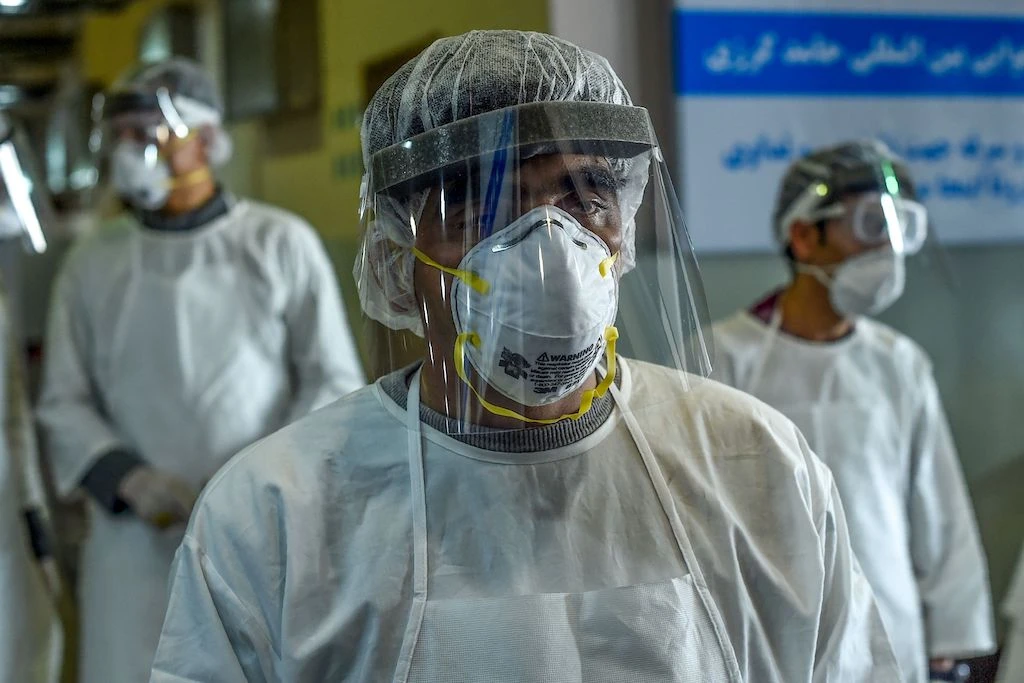 Health services staff members wearing protective gear look on as they wait to check passengers at the Hamid Karzai International Airport in Kabul on February 2, 2020. (AFP)