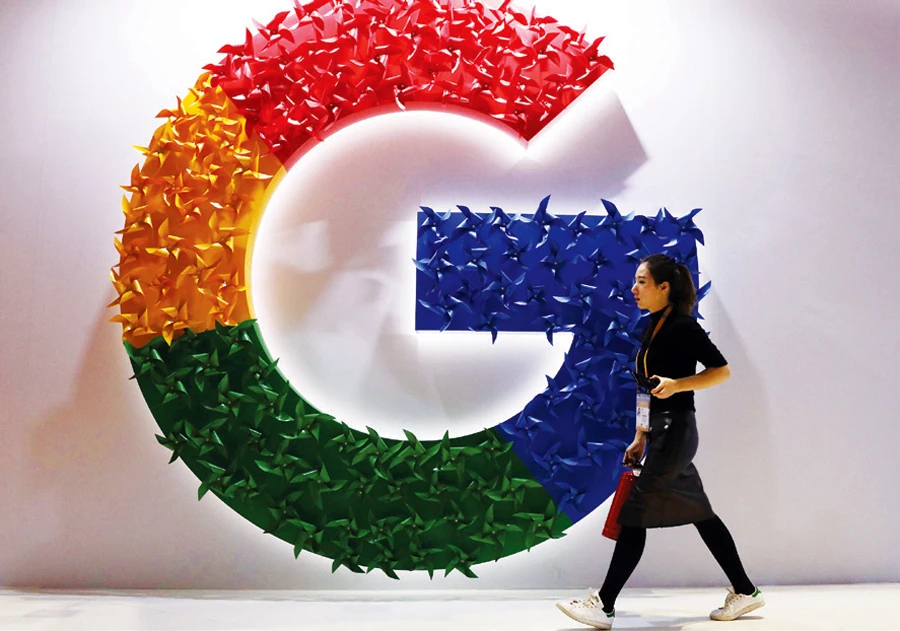 A woman walks past the logo for Google at the China International Import Expo in Shanghai. (AP)