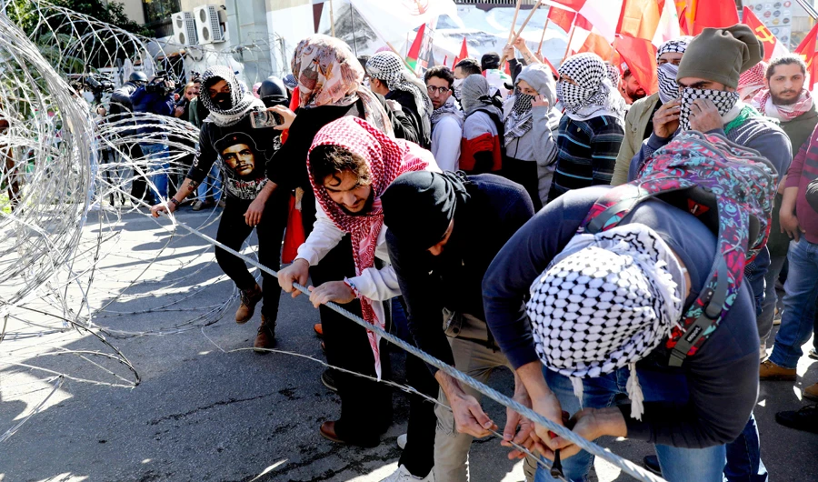 Lebanese demonstrators pull on a barbed wire as they take part in an demonstration against the US peace plan proposal, near the US embassy in Awkar, northeast of the capital Beirut on February 2, 2020. (AFP)