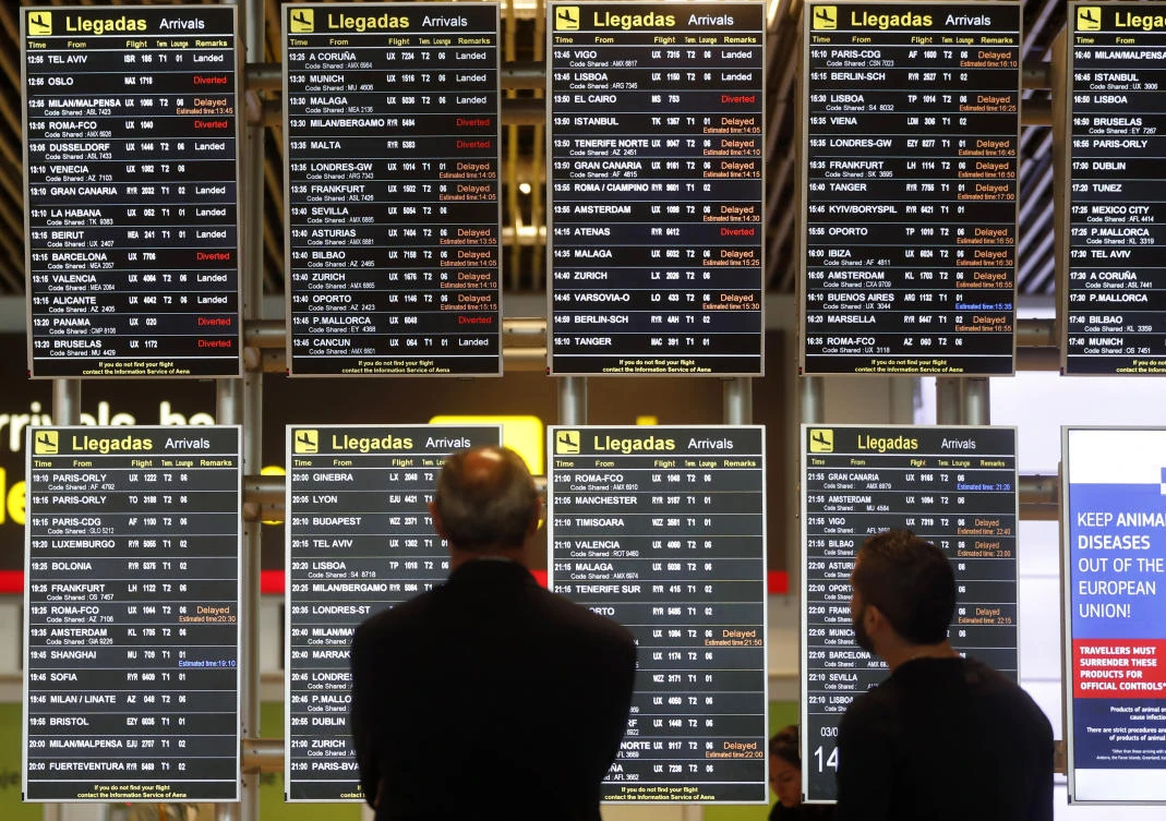 People look at their flight information shown at displays at the Adolfo Suárez-Barajas airport in Madrid, Spain, Monday, Feb. 3, 2020. Madrid's international airport was resuming air traffic after nearly two hours of airspace closure following the reported sighting of drones, Spanish authorities said Monday. (AP)