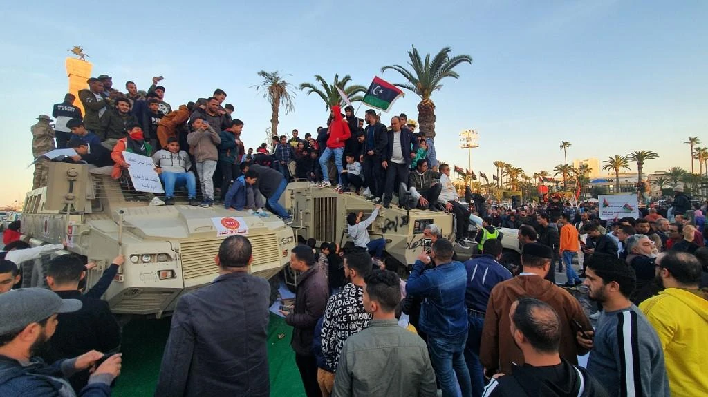 Libya has been mired in chaos since a 2011 NATO-backed uprising that killed longtime dictator Muammar Qaddafi. Above, people stand and sit with Libyan national flags above armored vehicles of forces loyal to the UN-recognized Government of National Accord on January 31, 2020. (AFP)