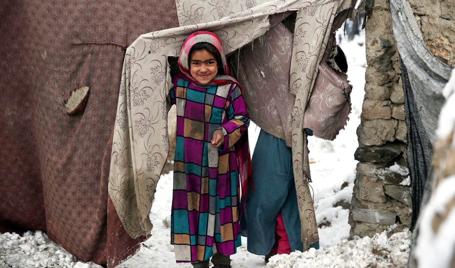 In this, Jan. 12, 2020, file photo, a young Afghan refugee peers from her temporary home after a snowstorm at a camp on the outskirts of Kabul, Afghanistan. (AP)