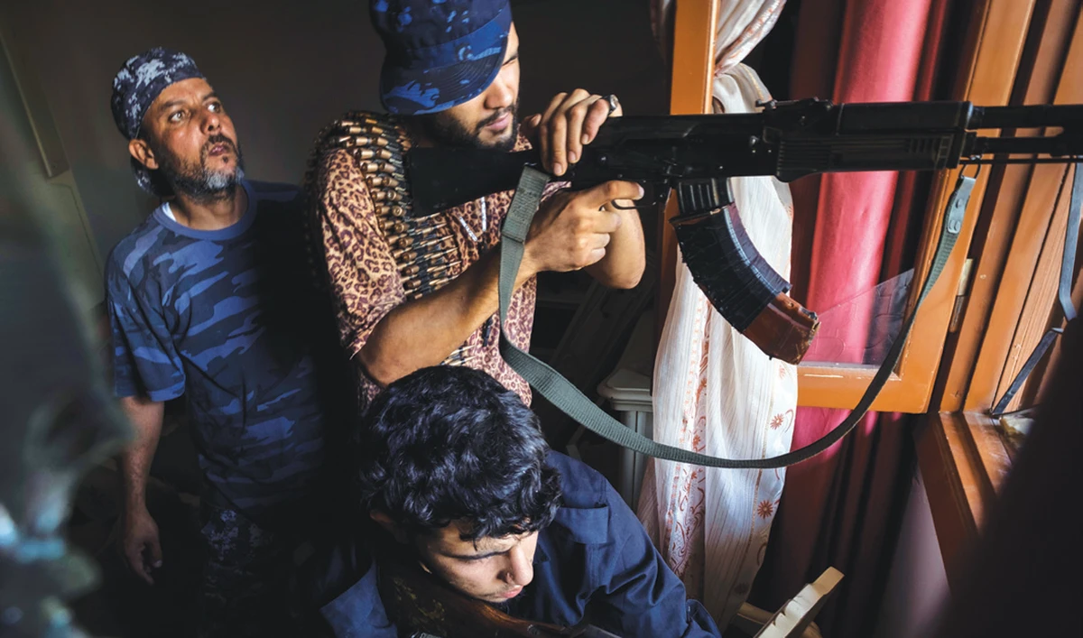 Fighters of the ‘Shelba’ unit, a militia allied with the UN-supported Libyan regime, aim at enemy positions at the Salahaddin neighborhood in Tripoli. (AP)