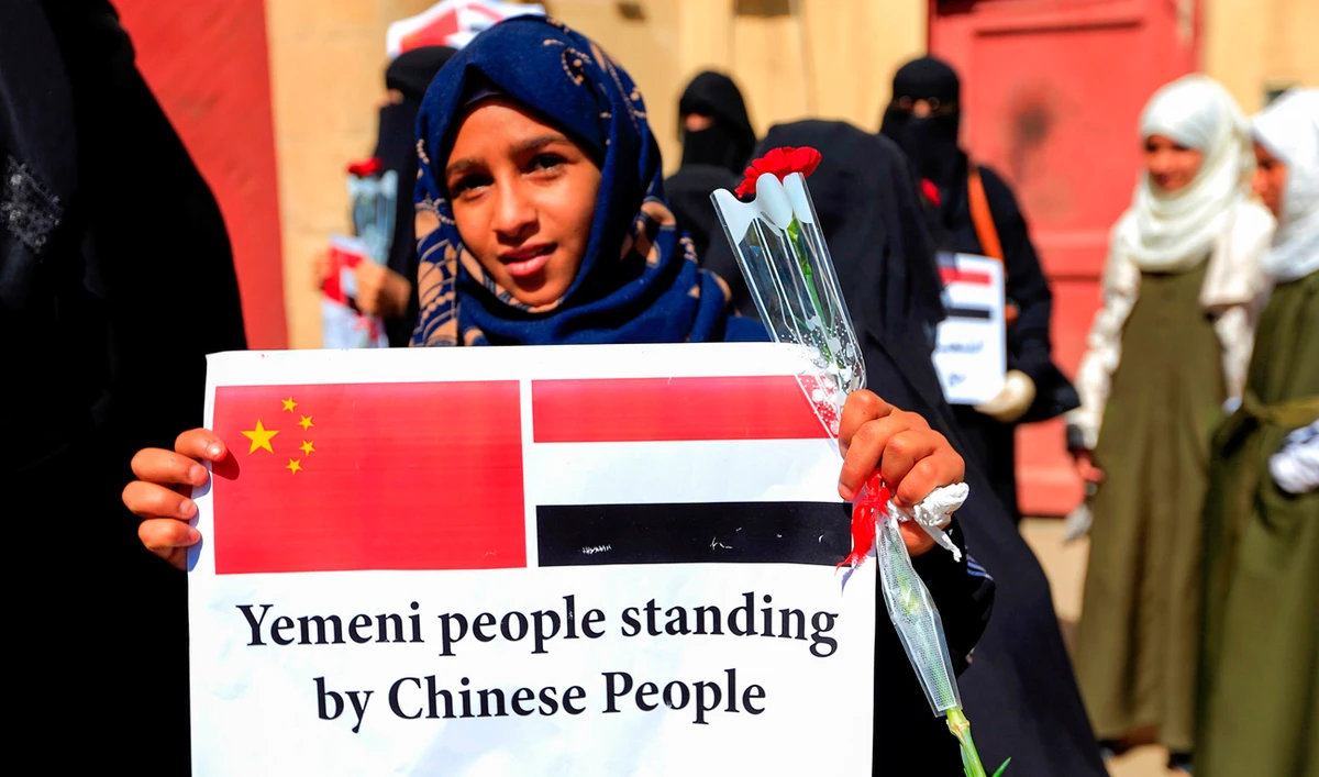 Yemenis gather with flowers outside the Chinese embassy in the capital Sanaa on February 4, 2020, to express their solidarity with people in China suffering from the Coronavirus. (AFP)