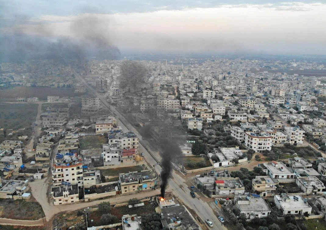 An aerial view taken on February 6, 2020 shows smoke billowing from tyres burnt by Syrians in an attempt to hinder air strikes amid clashes between rebel fighters and government forces in the town of Binnish in Syria’s northwestern province of Idlib. (File/AFP)