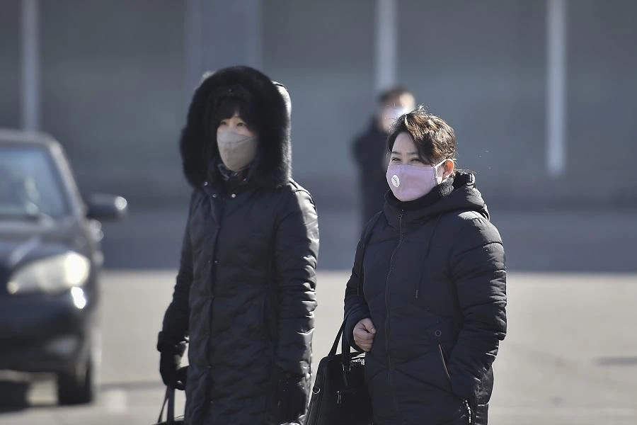 In this photo taken on February 6, 2020, people wearing face masks walk in Pyongyang. (File/AFP)
