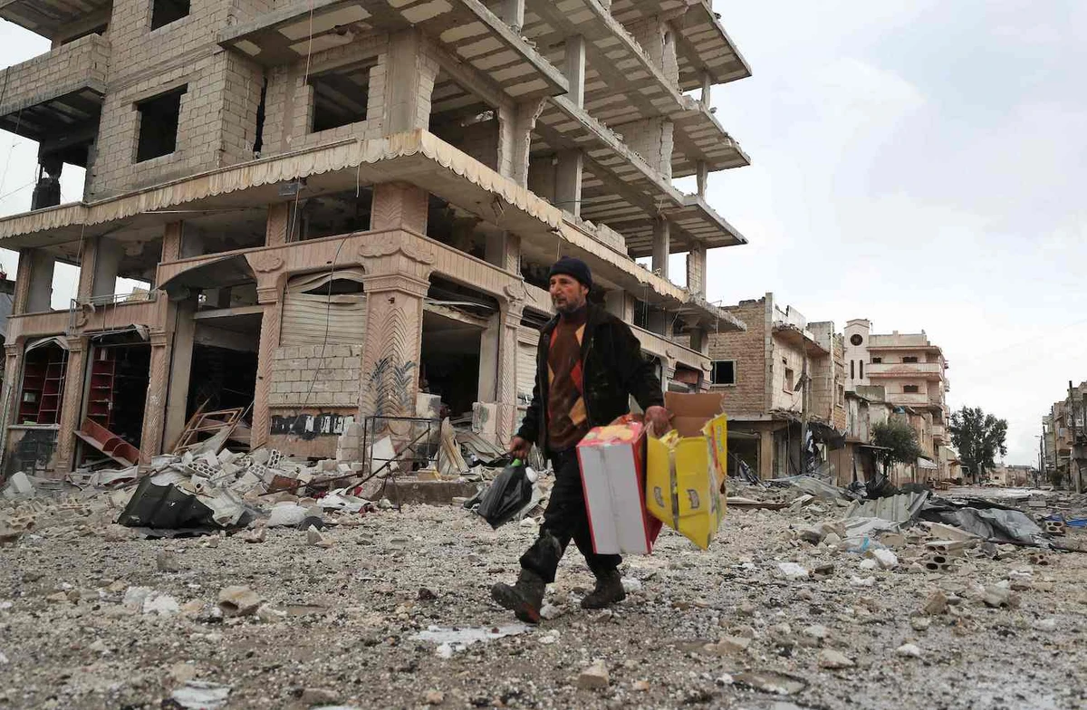 A Syrian who fled from the town of Sarmin, about 8 kilometres southeast of the city of Idlib in northwestern Syria, returns to the town to collect some belongings on Feb. 7, 2020. (AFP)