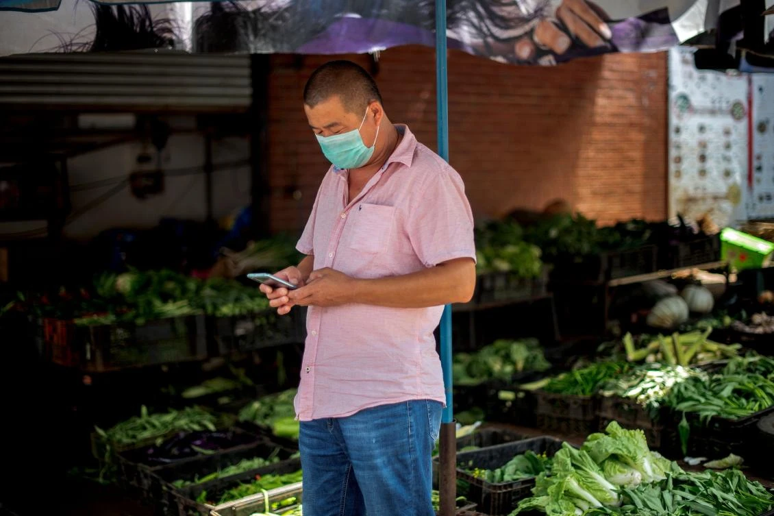 A man wears a protective face mask as he works at a vegetable market in Cyrildene, also known as Johannesburg's China Town, on Feb. 07, 2020. (AFP)