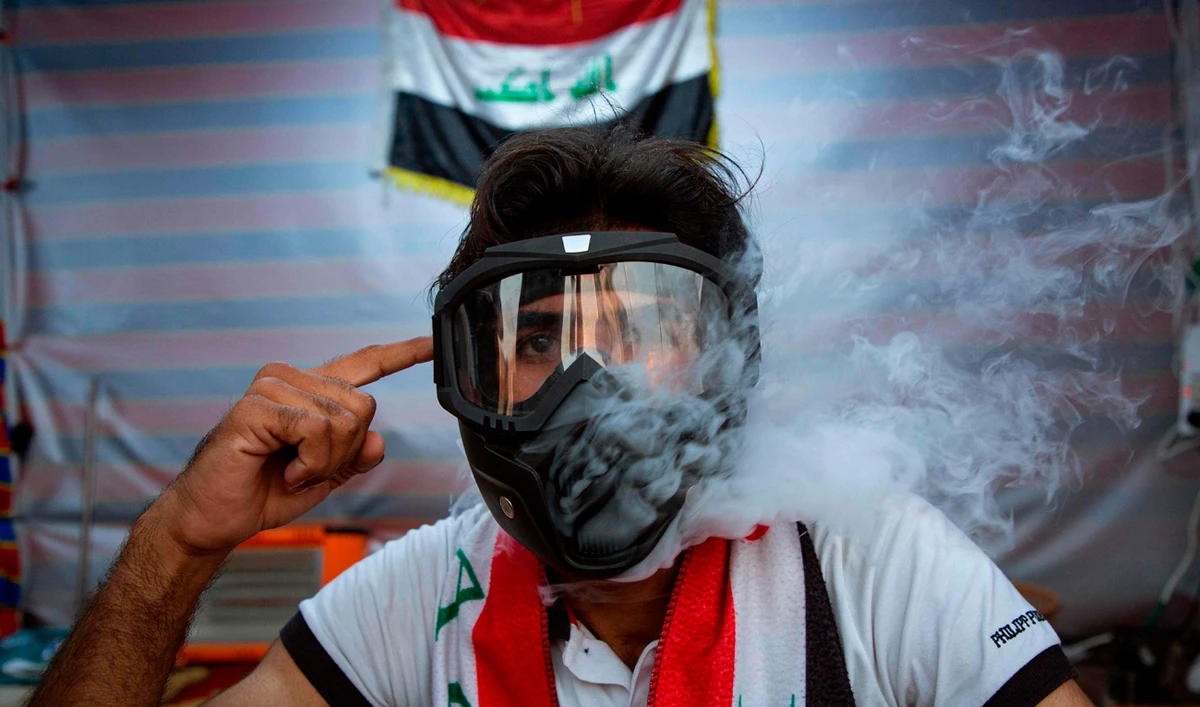 An Iraqi demonstrators smokes a shisha through a tear-gas mask during an anti-government demonstration in the southern city of Basra. (AFP)