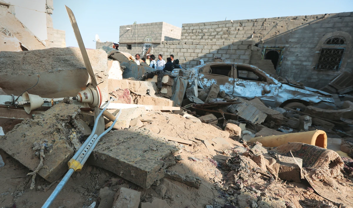 People stand at the site of a Houthi ballistic missile attack over the populated district of Rawda in Marib, Yemen, on Thursday. (Reuters)