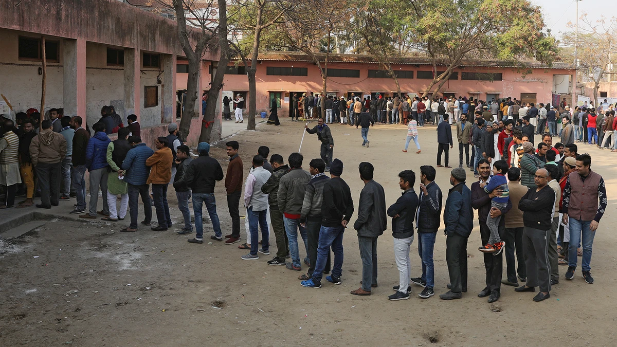 Voters stand in queues as they wait to cast their vote outside a polling booth during the state assembly election in New Delhi on Feb. 8, 2020. (REUTERS)