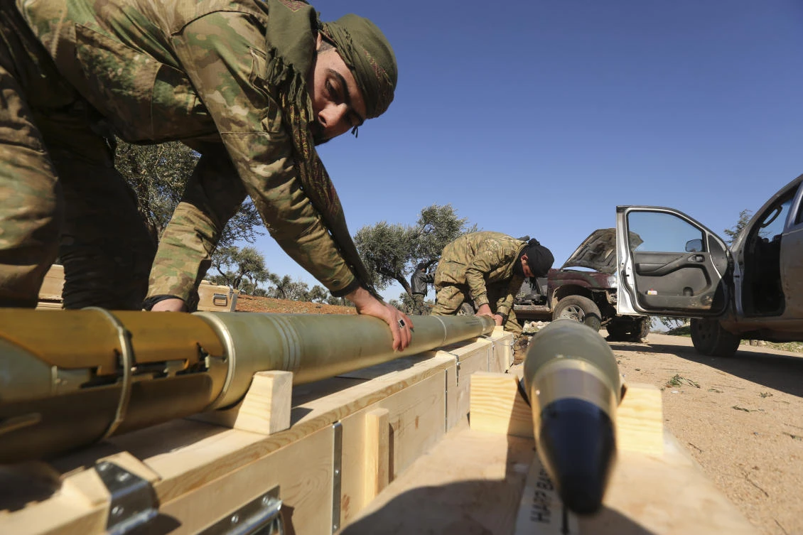 Rebel fighters prepare to fire a missile towards Syrian government positions in the province of Idlib, Sunday, Feb. 9, 2020.Syria's military vowed on Sunday to keep up its campaign to regain control of the whole country, days after capturing large chunks of territory from the last rebel holdout in northwestern Syria. (AP Photo/Ghaith Alsayed)