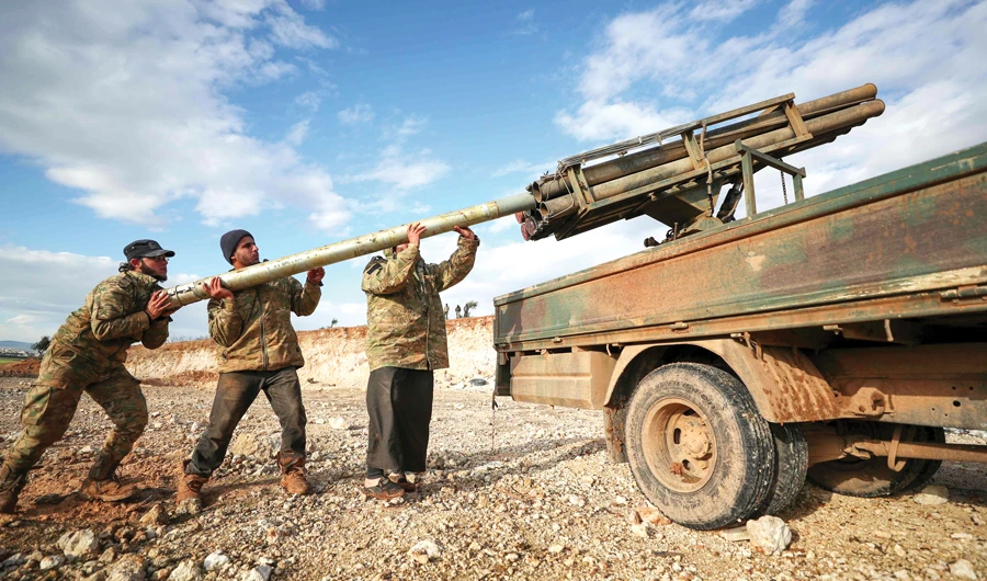 Syrian rebel fighters load a Grad rocket launcher in northwestern Syria on Saturday. Since December, regime forces have pressed a blistering assault against the Idlib region with Russian support. (AFP)