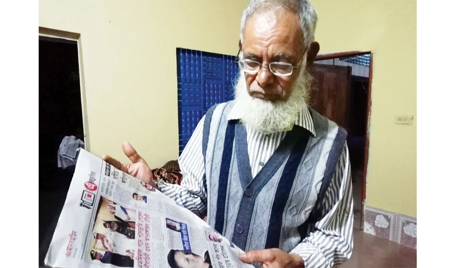 Shamima Begum’s father, Ahmed Ali, reads a new report about his daughter at his residence in Sylhet, Bangladesh. (AN photo by Shehab Sumon)