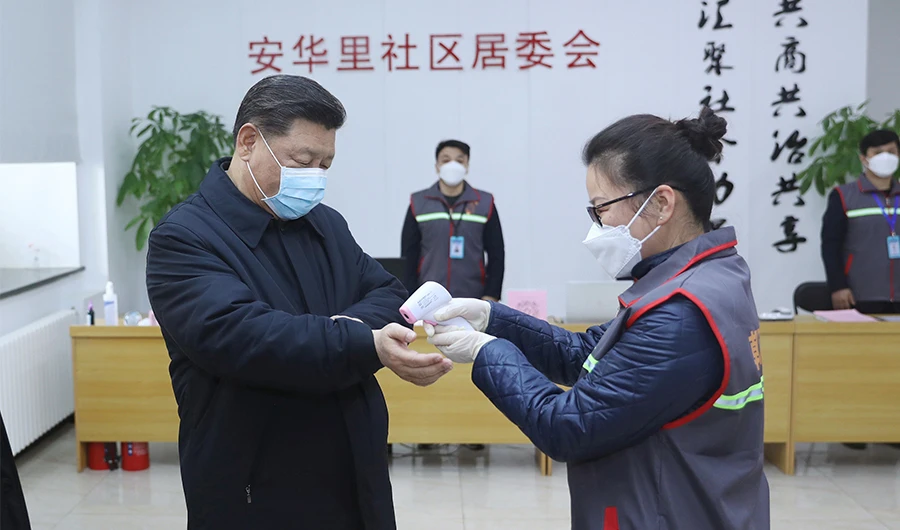 This photo released on February 10, 2020 by China's Xinhua News Agency shows Chinese President Xi Jinping (L) wearing a protective facemask as a health official (R) checks his body temperature during an inspection of the novel coronavirus pneumonia prevention and control work at the Anhuali Community in Beijing. (AFP)