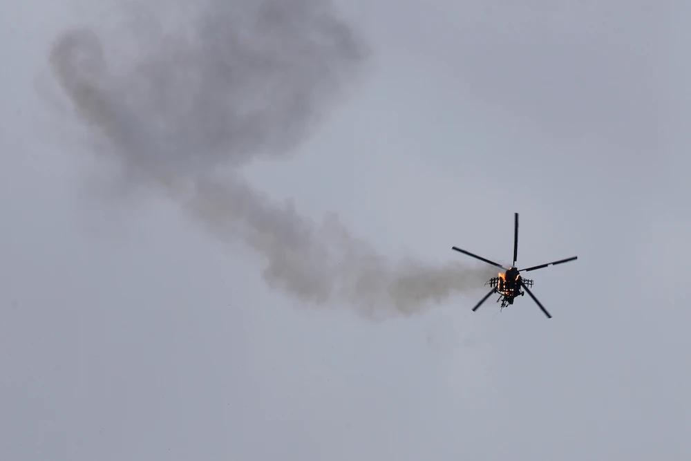 A Syrian government helicopter bursts in flames after it was shot by a missile in Idlib province on Tuesday. (AP)